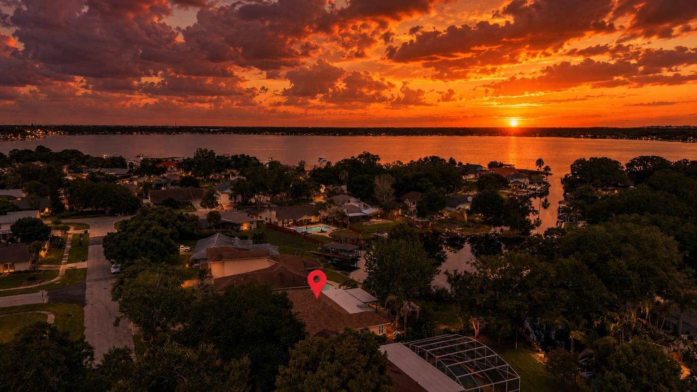 Aerial view at sunset of the home, canal and Conway Chain of Lakes at 3625 Waters Edge Dr, Belle Isle Florida