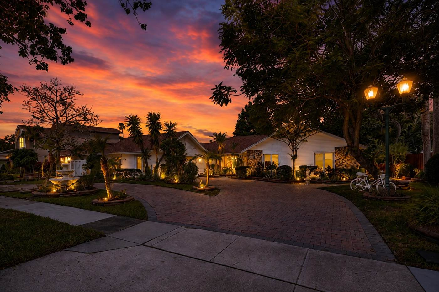 Front elevation at twilight with U-shaped paver driveway at 3625 Waters Edge Dr, Belle Isle Florida