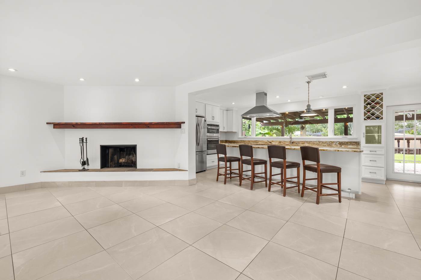 Great room with tile floors, fireplace and kitchen bar at 3625 Waters Edge Dr, Belle Isle Florida
