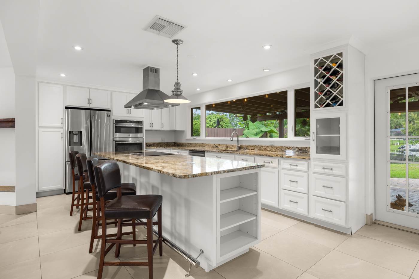 Kitchen with granite island, pendant lighting and stainless appliances at 3625 Waters Edge Dr, Belle Isle Florida
