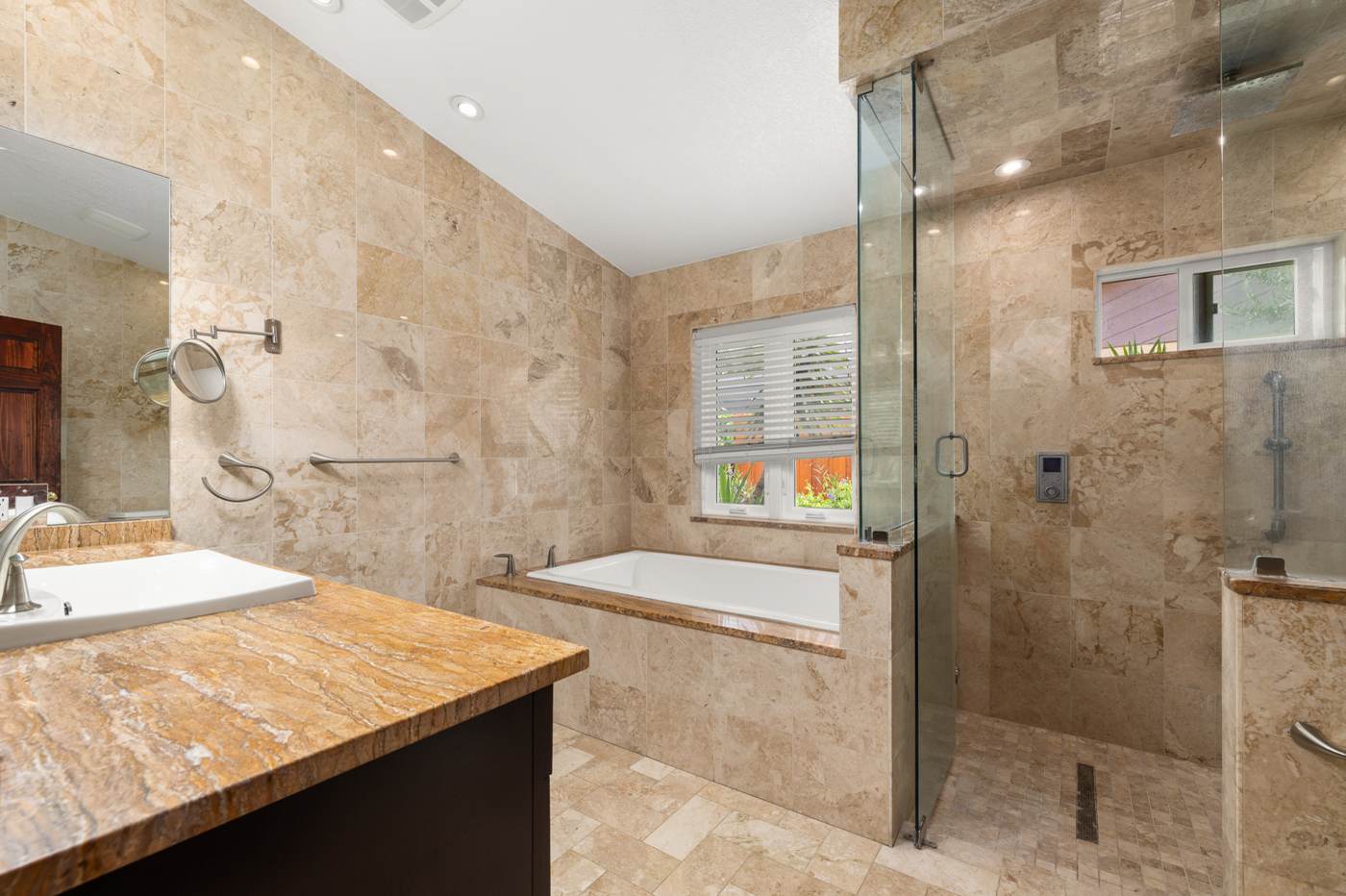 Marble tile primary bath with dual vanity, soaking tub and smart-control shower at 3625 Waters Edge Dr, Belle Isle Florida